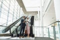 Business people with bags discussing over digital tablet near escalator in a modern office Royalty Free Stock Photo