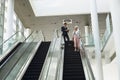 Business people talking on mobile phone and using digital tablet on escalator in a modern office Royalty Free Stock Photo