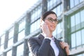 Low angle view of businesswoman using cell phone outside office building Royalty Free Stock Photo