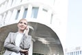 Low angle view of businesswoman using cell phone outside office building Royalty Free Stock Photo