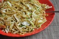 Low angle view of chowmein noodles served in red color plate in the cafe