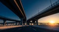 Elevated Highway Interchange at Sunset with Dramatic Sky and Sun Flare road traffic Royalty Free Stock Photo