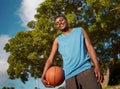 Low angle view of a confident male basketball player holding ball in hand looking to camera Royalty Free Stock Photo