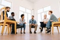 Low-angle view of confident mature male coach psychologist talking sitting in circle during group therapy with diverse Royalty Free Stock Photo