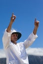 Low angle view of cricket umpire signalling six runs against blue sky