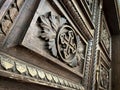 Low angle view of cross symbol with ornaments carved on old wooden door Royalty Free Stock Photo