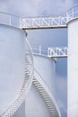 Spiral staircase on white storage fuel tanks in vertical frame