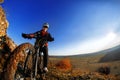 Low angle view of cyclist riding mountain bike on rocky trail at sunrise Royalty Free Stock Photo