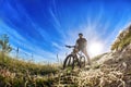 Low angle view of cyclist standing with mountain bike on trail at sunrise. Royalty Free Stock Photo