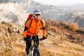 Low angle view of cyclist standing with mountain bike on trail at sunset Royalty Free Stock Photo