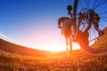 Low angle view of cyclist standing with mountain bike on trail at sunset Royalty Free Stock Photo