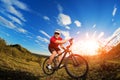 Low angle view of cyclist standing with mountain bike on trail at sunset Royalty Free Stock Photo