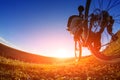 Low angle view of cyclist standing with mountain bike on trail at sunset Royalty Free Stock Photo