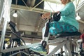 Disabled active senior woman using mobile phone while exercising in fitness studio Royalty Free Stock Photo