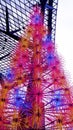 A vertical shot from a modern steel Christmas tree with colorful electric lights