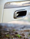 Low angle view of the exhaust pipe of a car with selective focus on tailpipe vertical