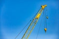 Yellow crane jib hoist against blue sky Royalty Free Stock Photo