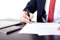 Low angle view of the fingers of a man writing on a document with a fountain pen conceptual of communication