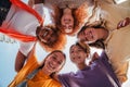 Low angle view of five teenage girls laughing and looking at camera. Group of young women smiling looking down. Real Royalty Free Stock Photo