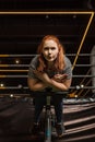 Angle view of focused overweight girl doing lower back extension exercise on training machine