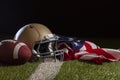 Low angle view of a football and helmet with American flag on a grass field with stripe Royalty Free Stock Photo