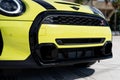 Low angle view of front bumper of yellow Mini Convertible S Cooper with black radiator grille and led headlights