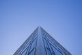 Low angle view of glass facade of tall office building against clear blue sky Royalty Free Stock Photo