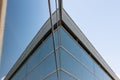 Low angle view of the glass facade of a tall office building against a clear blue sky, Royalty Free Stock Photo