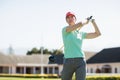 Low angle view of golfer woman taking shot Royalty Free Stock Photo