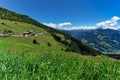 Low angle view of green meadow and alpine village with high mountains under blue sky. Austria, Tirol, Zillertal, Zillertal, High A Royalty Free Stock Photo