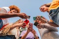 Low angle view of a group of smiling multiracial teenage women addicted to smartphones, watching videos, shopping online Royalty Free Stock Photo