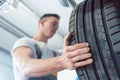 Low-angle view of the hand of a skilled auto mechanic holding a tire