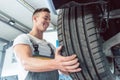 Low-angle view of the hand of a skilled auto mechanic holding a tire