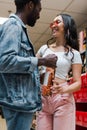 Angle view of happy african american man holding bottle near asian girl in sunglasses Royalty Free Stock Photo