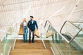 Low-angle view of happy beautiful young couple holding shopping paper bags with purchases and walking down stairs Royalty Free Stock Photo