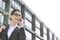 Low angle view of happy businesswoman using cell phone outside office building Royalty Free Stock Photo