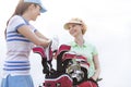 Low angle view of happy female golfers talking against clear sky Royalty Free Stock Photo