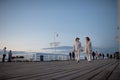 Low angle view of happy senior couple in love on walk outdoors on pier by sea at dusk, holding hands. Royalty Free Stock Photo