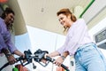 Angle view of happy woman holding fuel pump while refueling car with benzine