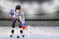 Boy Wearing Mask Practicing Hockey Skills at Empty Ice Rink During COVID-19 Pandemic