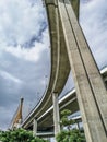 Low angle view of huge and stately bridge with strong pillar with cloudy sky in the background, urban and futuristic concept Royalty Free Stock Photo