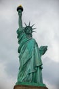 Low-angle view of the iconic Statue of Liberty standing against a cloudy sky