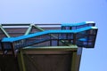 Low angle view on industrial modern building with open blue stairways against heaven
