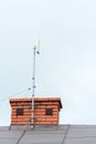 Low angle view of a internet antenna fixed to the chimney on the tile roof Royalty Free Stock Photo