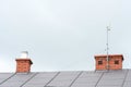 Low angle view of a internet antenna fixed to the chimney on the tile roof Royalty Free Stock Photo