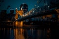 Low-angle view of John A. Roebling Suspension Bridge before the Covington buildings at night Royalty Free Stock Photo