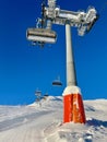 Low angle view of lift support and chairlift against blue sky. Vertical.