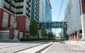 Low angle view of light rail tracks running under elevated walkway between two buildings in Charlotte, North Carolina, USA Royalty Free Stock Photo