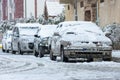 Low angle view of a line of cars covered with snow.