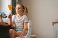 Low-angle view of little girl holding beautiful dried maple leaf to create herbarium diy at home. Royalty Free Stock Photo